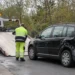 Mitarbeiter eines Abschleppdienstes in gelber Warnkleidung lädt einen beschädigten schwarzen Kombi auf einen Abschleppwagen.