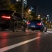 Zwei sportliche Fahrzeuge liefern sich nachts auf einer städtischen Straße ein illegales Autorennen