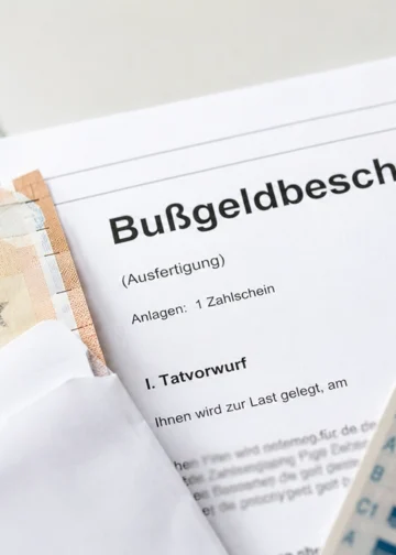 Bußgeldbescheid mit Euro-Banknoten und Führerschein als Symbolbild für Bußgeldverfahren, Einspruch und Fristen 2026