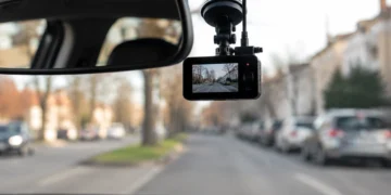An der Windschutzscheibe montierte Dashcam im Auto mit Blick auf eine unscharfe Straße im Stadtverkehr