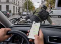 Radfahrer liegt nach einem Zusammenstoß auf der Motorhaube, der Fahrer hält noch sein Smartphone mit geöffnetem Chat in der Hand