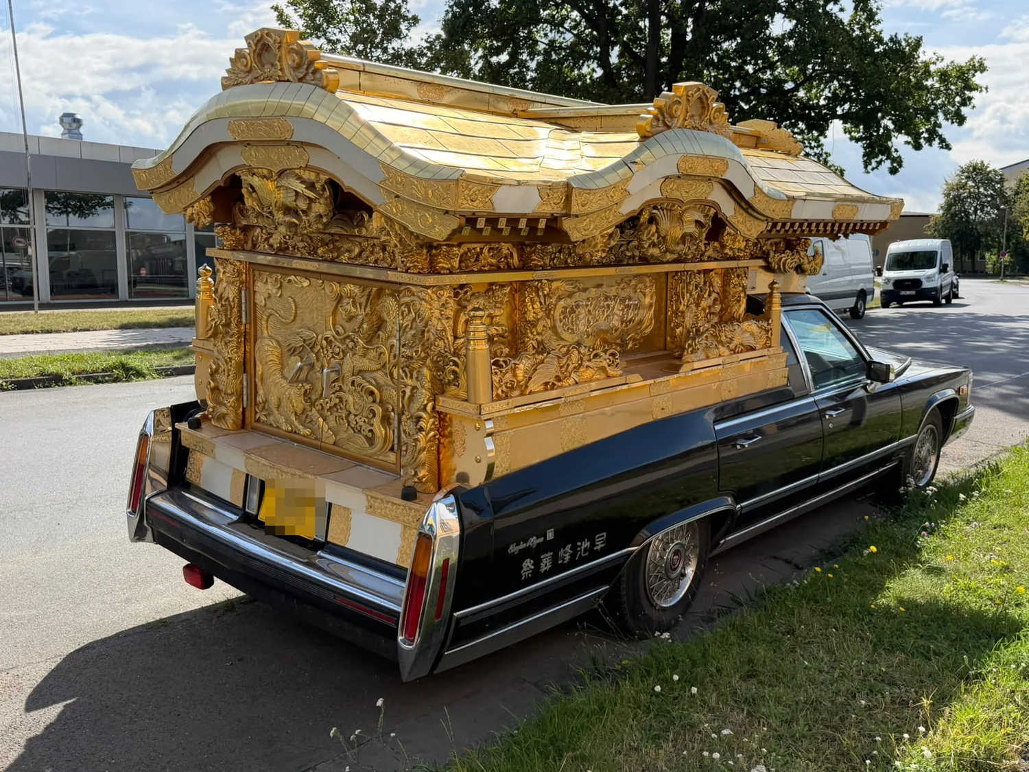 Heckansicht des Fahrzeugs, der vergoldete Aufbau zeigt geschnitzte Drachen und ein doppelt geschwungenes Dach.