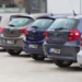 Reihe geparkter Kompaktwagen verschiedener Marken von hinten fotografiert