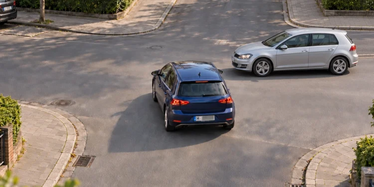 Zwei Fahrzeuge nähern sich einer unbeschilderten Kreuzung in einem Wohngebiet