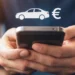 Hände halten ein Smartphone, darüber schweben ein weißes Auto-Symbol und ein Euro-Zeichen