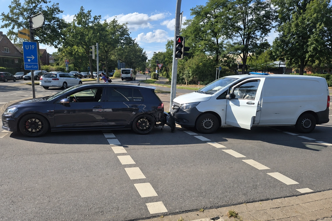 Seitenansicht eines Auffahrunfalls zwischen einem dunklen VW Golf und einem weißen Transporter an einer Kreuzung.